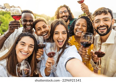 Multiracial friends drinking red wine outside at farm house vineyard countryside - Group of young people taking selfie picture outdoor - Life style concept with guys and girls enjoying summer vacation - Powered by Shutterstock