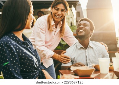 Multiracial friends eating at food truck restaurant outdoor - Focus on senior woman hand - Powered by Shutterstock