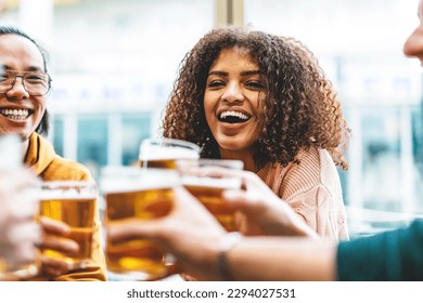 Multiracial friends enjoying beer at brewery pub- Group of happy people toasting glasses sitting at table bar and having fun- Lifestyle Food and beverage Concept with diverse guys and girls

 - Powered by Shutterstock