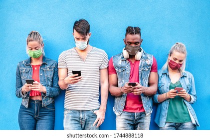 Multiracial Friends With Face Masks Using Tracking App With Mobile Smart Phones - Young Milenial People Watching Content On Social Media Networks - New Normal Lifestyle Concept - Bright Vivid Filter