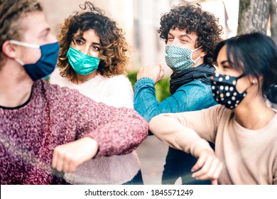 Multiracial Friends Greeting With Elbow Bump Wearing Face Protection - New Normal Lifestyle Concept With Young People Covered By Disposable Mask - Selective Focus On Middle Left Woman 