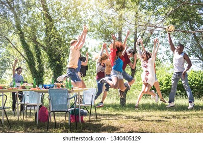 Multiracial Friends Jumping At Barbecue Pic Nic Garden Party - Friendship Multicultural Concept With Young Happy People Having Fun Dancing Out At Spring Break Camp Festiva - Bright Warm Filter