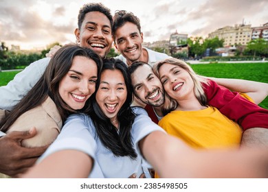 Multiracial friends smiling at camera outdoors - Happy group of young people taking selfie picture with smart mobile phone device - Friendship concept with guys and girls hanging outside - Powered by Shutterstock