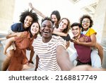 Multiracial friends taking selfie group picture with smart mobile phone outside on city street - Happy young people smiling together looking at camera - Youth lifestyle concept with teens hanging out