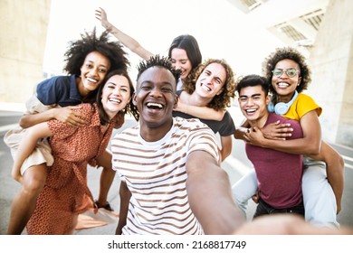 Multiracial friends taking selfie group picture with smart mobile phone outside on city street - Happy young people smiling together looking at camera - Youth lifestyle concept with teens hanging out - Shutterstock ID 2168817749