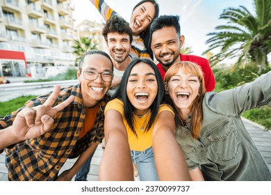Multiracial friends taking selfie pic with smart mobile phone outside - Happy young people having fun talking on city street - Life style concept with guys and girls hanging out on a sunny day  - Shutterstock ID 2370099737