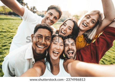 Multiracial friends taking selfie pic with smart mobile phone outside - Happy young people laughing together at camera - Youth community concept with guys and girls hanging out on sunny day