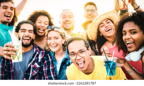 Multiracial friends taking selfie at sunset concert on vacation day - Party life style concept with young people having fun together at spring break beach festival - Vivid filter with sunshine halo - Powered by Shutterstock