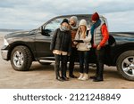 Multiracial friends talking and using tablet computer during car trip