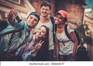 Multiracial friends tourists making selfie in an old city 