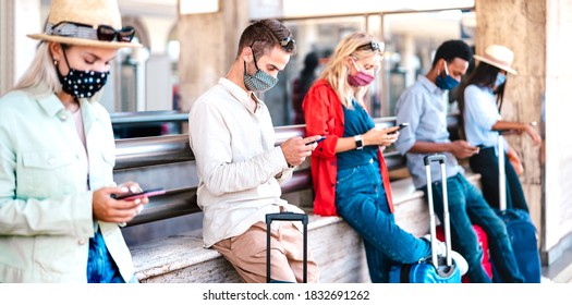 Multiracial friends wearing face mask using mobile smart phones - Young millenial checking online reservations at train station - New normal travel and lifestyle concept - Vivid contrast filter - Powered by Shutterstock