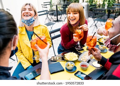 Multiracial Friends Wearing Face Masks Drinking Cocktails At Bar Restaurant - New Normal Friendship Concept With Young People Enjoying Meal In Backyard Party 