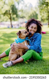 Multiracial Girl Sitting And Resting With Her Dog Outside In The Park, Training Him, Spending Leisure Time Together. Concept Of Relationship Between Dog And Teenager, Everyday Life With Pet.