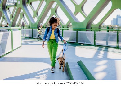 Multiracial Girl Walking With Her Dog Outside In The Bridge, Training Him, Spending Leisure Time Together. Concept Of Relationship Between Dog And Teenager, Everyday Life With Pet.