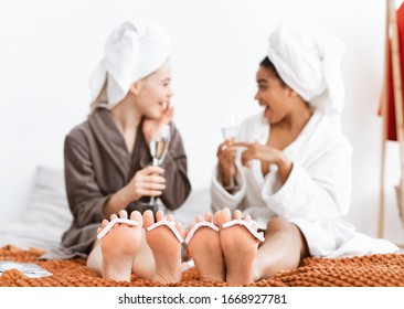 Multiracial Girlfriends Having Spa Day At Home, Drinking Champagne, Making Pedicure, Sharing Secrets