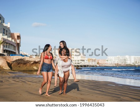 Multiracial girls enjoy summer vacation together on the beach - Happy women with different body and skin colors having fun outdoor