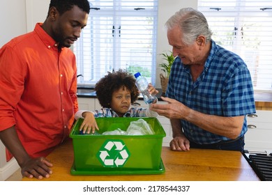 Multiracial grandfather and father teaching boy to recycle waste by throwing plastic bottles in bin. Multigeneration, unaltered, together, childhood, unaltered, environmental conservation, garbage. - Powered by Shutterstock