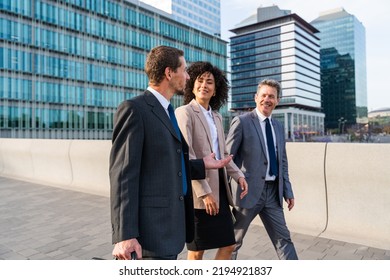 Multiracial group of business people bonding outdoors - International business corporate team wearing elegant suit meeting in a business park - Powered by Shutterstock