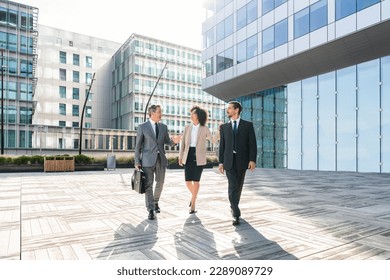 Multiracial group of business people bonding outdoors - International business corporate team wearing elegant suit meeting in a business park - Powered by Shutterstock