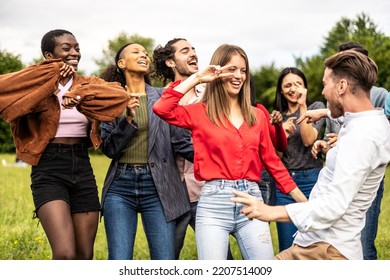 Multiracial group of friends dancing together on the park - Multiethnic friends having fun in the university campus - Shutterstock ID 2207514009