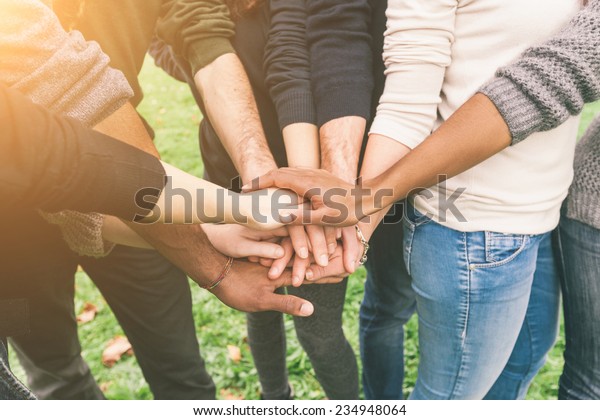 Multiracial Group of Friends with Hands in\
Stack, Teamwork