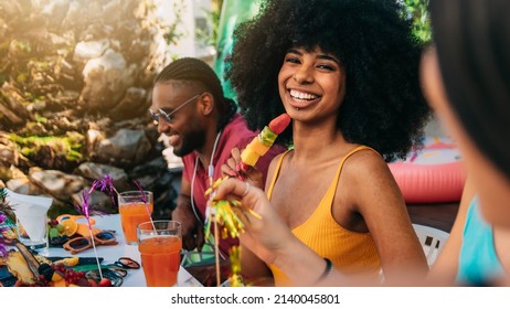 Multiracial Group Of Friends Having Fun At Backyard Home Party - Young People Laughing Together Drinking Cocktails At Bar Restaurant - Focus On Black Woman