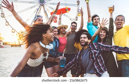 Multiracial group of friends having fun dancing on the beach - Happy people enjoying music festival on weekend vacation - Joyful tourists celebrating summer holiday together - Youth lifestyle concept - Powered by Shutterstock