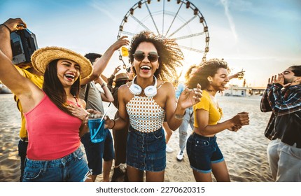 Multiracial group of friends having fun dancing at sunset beach party - Happy young people enjoying music festival on weekend vacation - Life style concept with guys and girls enjoying summer vacation - Powered by Shutterstock