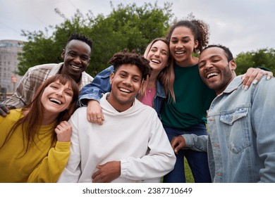 Multiracial group of friends outdoors smiling and having fun. International students happy together looking at camera. Portrait of young people from generation Z . Intercultural relations, community. - Powered by Shutterstock