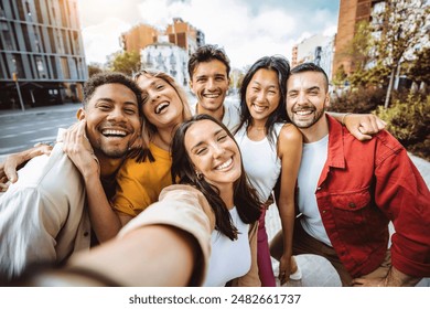 Multiracial group of friends taking selfie pic with smart mobile phone device - Happy young people having fun walking in city street - Technology and people life style concept - Powered by Shutterstock