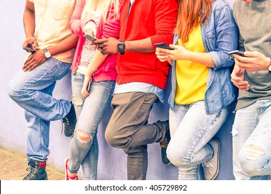 Multiracial group of friends texting sms and looking down to cell phone - Interracial students hands using mobile - Concept of young people addiction to web technology - Focus on hand of red hair girl