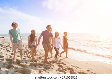 Multiracial Group Of Friends Walking At Beach