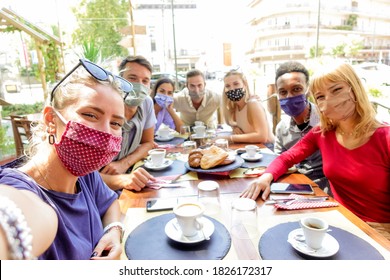 Multiracial group of friends wearing protection mask at the restaurant. Happy people celebrating toasting red wine taking a selfie with smartphone.  - Powered by Shutterstock