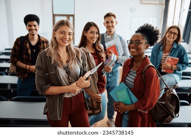 Multiracial group of happy college students int he classroom looking at camera. 
