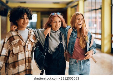 Multiracial group of happy high school friends walking through hallway at school. - Powered by Shutterstock