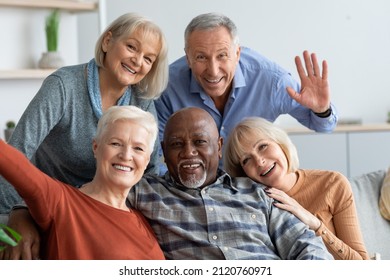 Multiracial group of happy positive elderly people men and women in casual outfits taking selfie together while chilling together, hugging and smiling at camera, nursing home interior - Shutterstock ID 2120760971