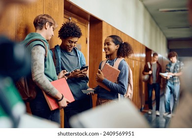 Multiracial group of happy students using mobile phones in hallway at high school. - Powered by Shutterstock