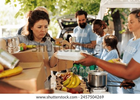 Multiracial group offers assistance by distributing food to the poor and needy. Volunteers of different ethnicities join together to aid homeless people by participating in humanitarian food drive.