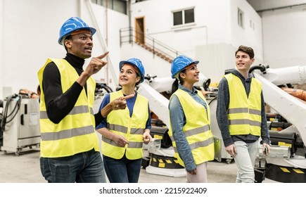 Multiracial group of people in blue helmets and fluorescent vests standing and talking about industrial machinery they are watching - focus in woman - - Powered by Shutterstock