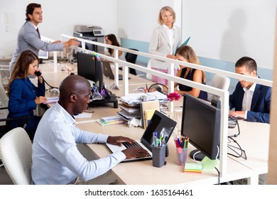 Multiracial group of  serious positive business people during daily work in modern co-working space