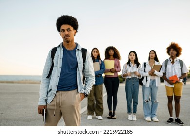 Multiracial Group Of Students Standing Outdoors With Books In Their Hands And Posing. Focus Is On African American Young Adult Male Student