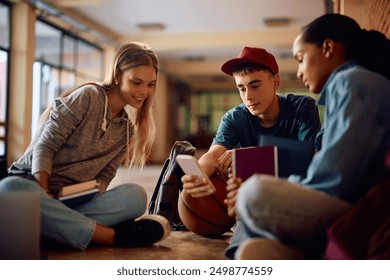 Multiracial group of students using mobile phone at high school hallway. - Powered by Shutterstock