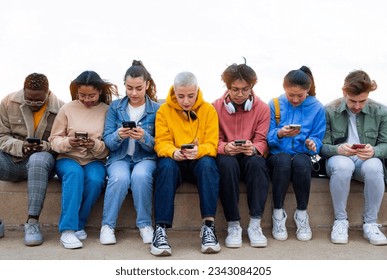Multiracial group of teen college students ignoring each other looking at mobile phone checking social media. - Shutterstock ID 2343084205