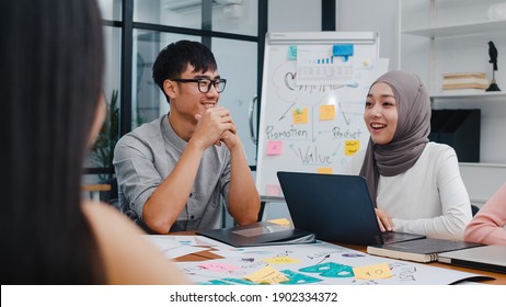 Multiracial Group Of Young Creative People In Smart Casual Wear Discussing Business Brainstorming Meeting Ideas Mobile Application Software Design Project In Modern Office. Coworker Teamwork Concept.