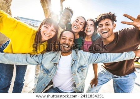 Multiracial group of young people smiling at camera outside - Happy friends having fun walking on city street - Youth community concept with different guys and girls hanging out on summer day time