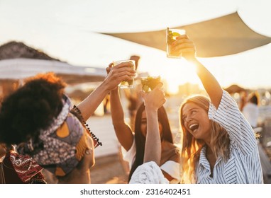 Multiracial happy friends cheering and drinking mojitos at beach party - Focus on left hand holding cocktail - Powered by Shutterstock