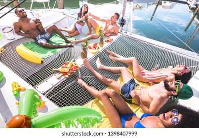 Multiracial happy friends having relax fun at sail boat party - Friendship concept with multi racial people on catamaran sailboat - Luxury travel and exclusive vacation concept - Vivid bright filter