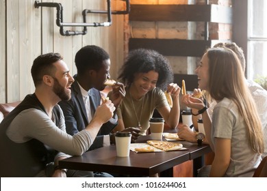 Multiracial happy young people eating pizza in pizzeria, black and white cheerful mates laughing enjoying meal having fun sitting together at restaurant table, diverse friends share lunch at meeting - Shutterstock ID 1016244061