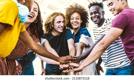 Multiracial happy young people putting their hands on top of each other - Diverse friends unity togetherness in volunteer community - Concept about college, relationship, creative, youth and community - Powered by Shutterstock