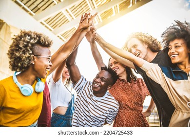 Multiracial happy young people putting their hands on top of each other - Diverse friends unity togetherness in volunteer community - Concept about college, relationship, creative, youth and community - Powered by Shutterstock